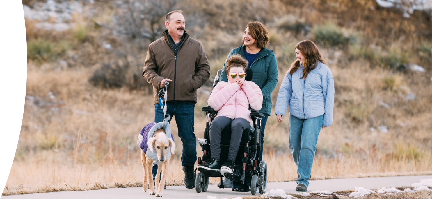 Maddy, age 21, living with Rett syndrome, with her family