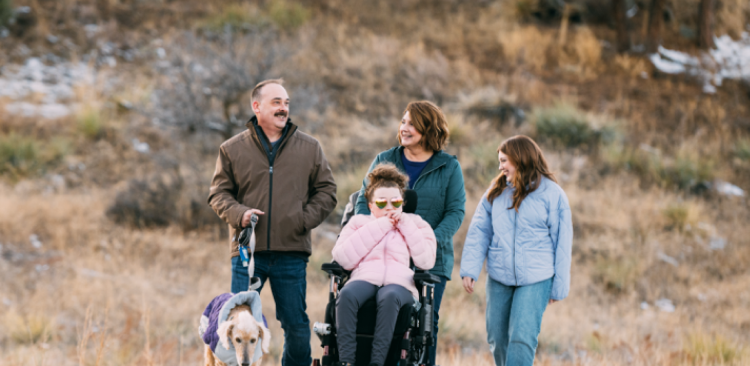Maddy, age 21, living with Rett syndrome, with her family